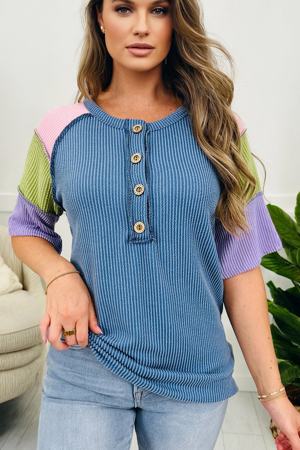 Woman wearing a colorful ribbed top with a blurred background