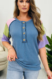 Woman wearing a colorful ribbed top with a blurred background