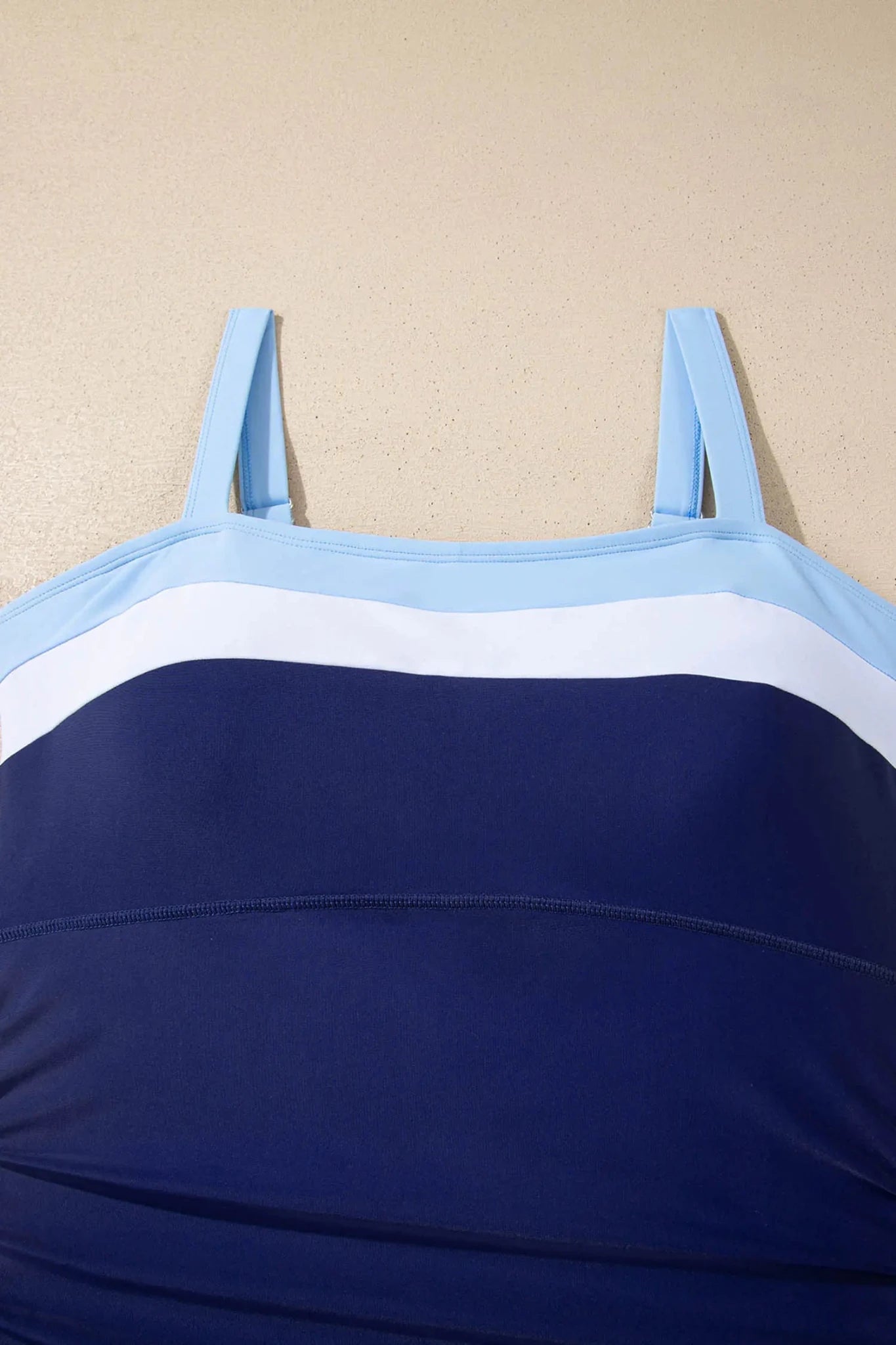 Blue and white striped top on a beige background