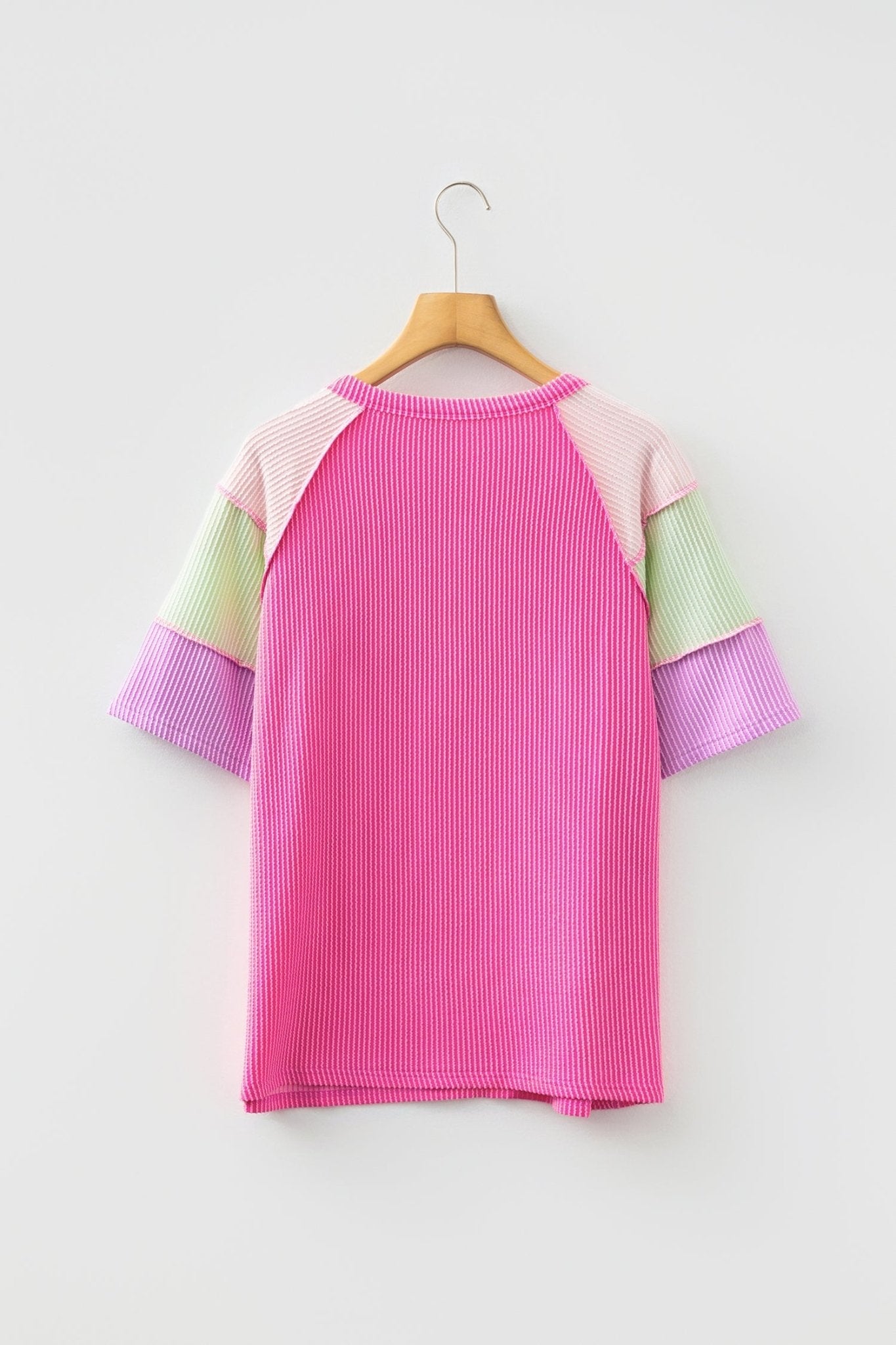 Color-blocked sweater on a hanger against a white background