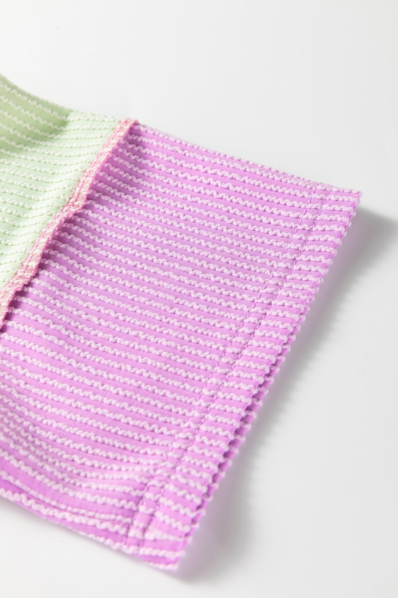 Pink and green knitted fabric on a white background