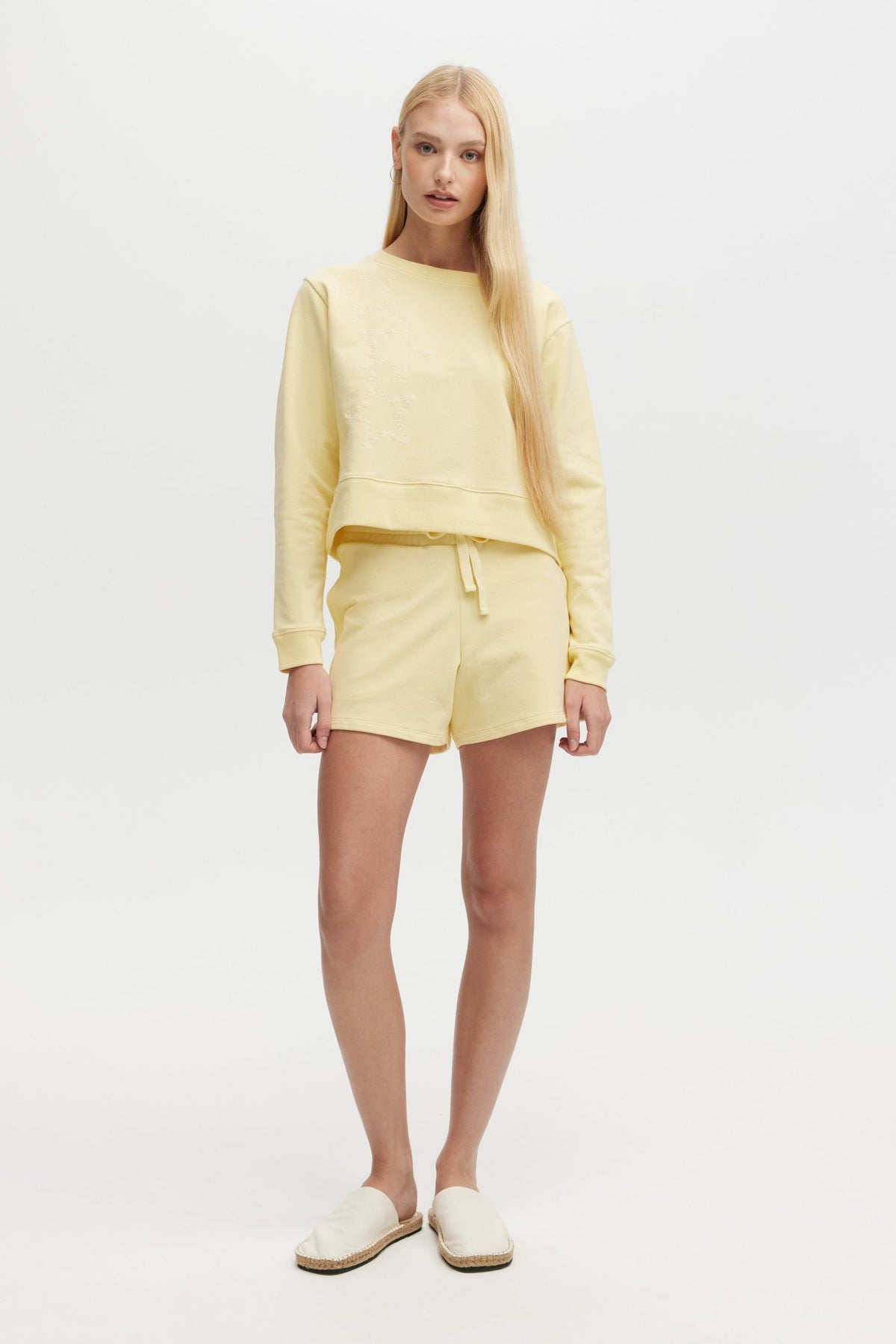 Woman wearing a yellow outfit on a white background