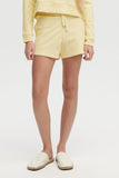 Person wearing yellow shorts and a matching top on a white background