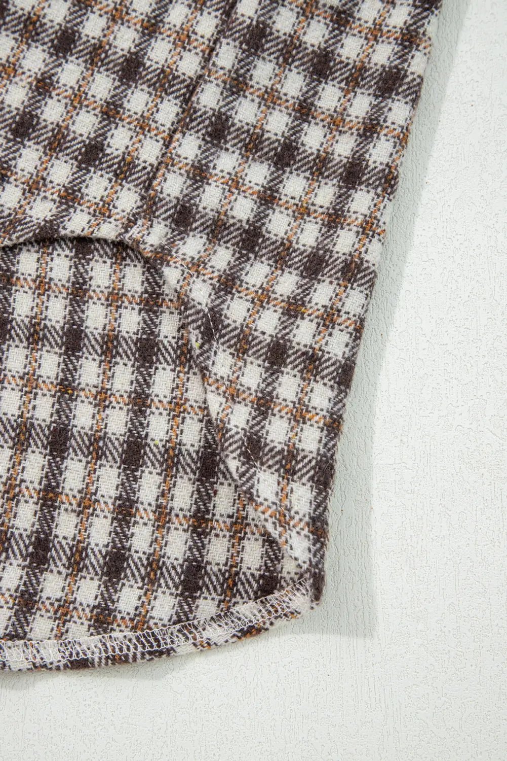 Close-up of checkered fabric with brown and white pattern on a light background
