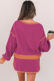 Woman wearing a purple dress with orange accents, holding a coffee cup.