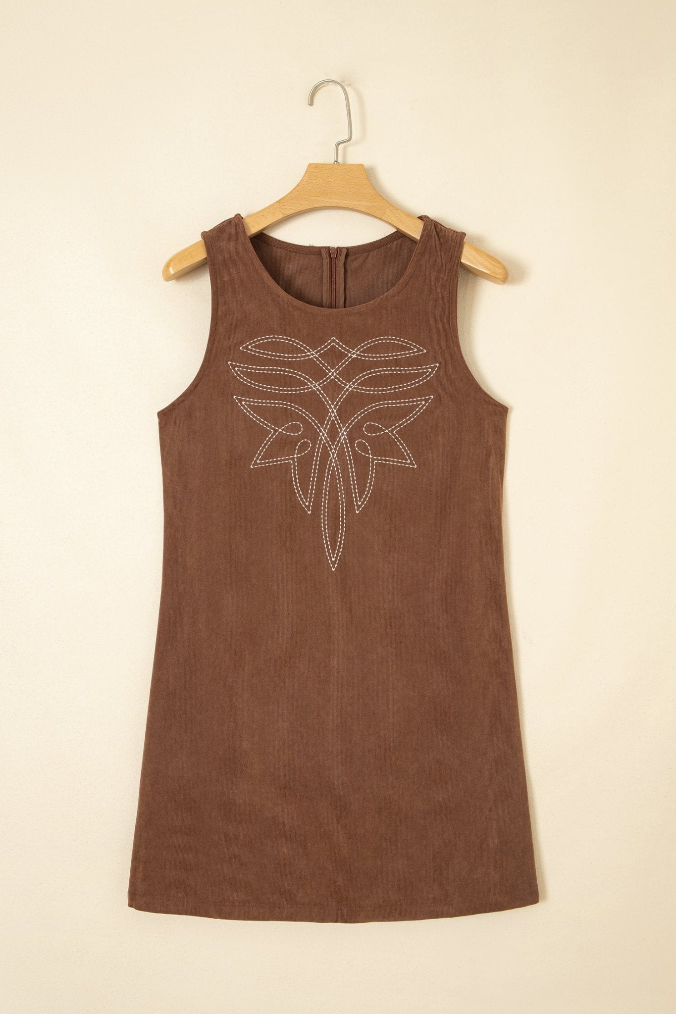 Sleeveless brown dress with white rhinestone chest graphic on wooden hanger.