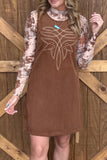 Woman in brown corduroy dress with white chest graphic over a tie-dye long-sleeve top.