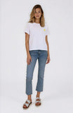 Woman wearing a white t-shirt with a small yellow logo and blue jeans on a white background
