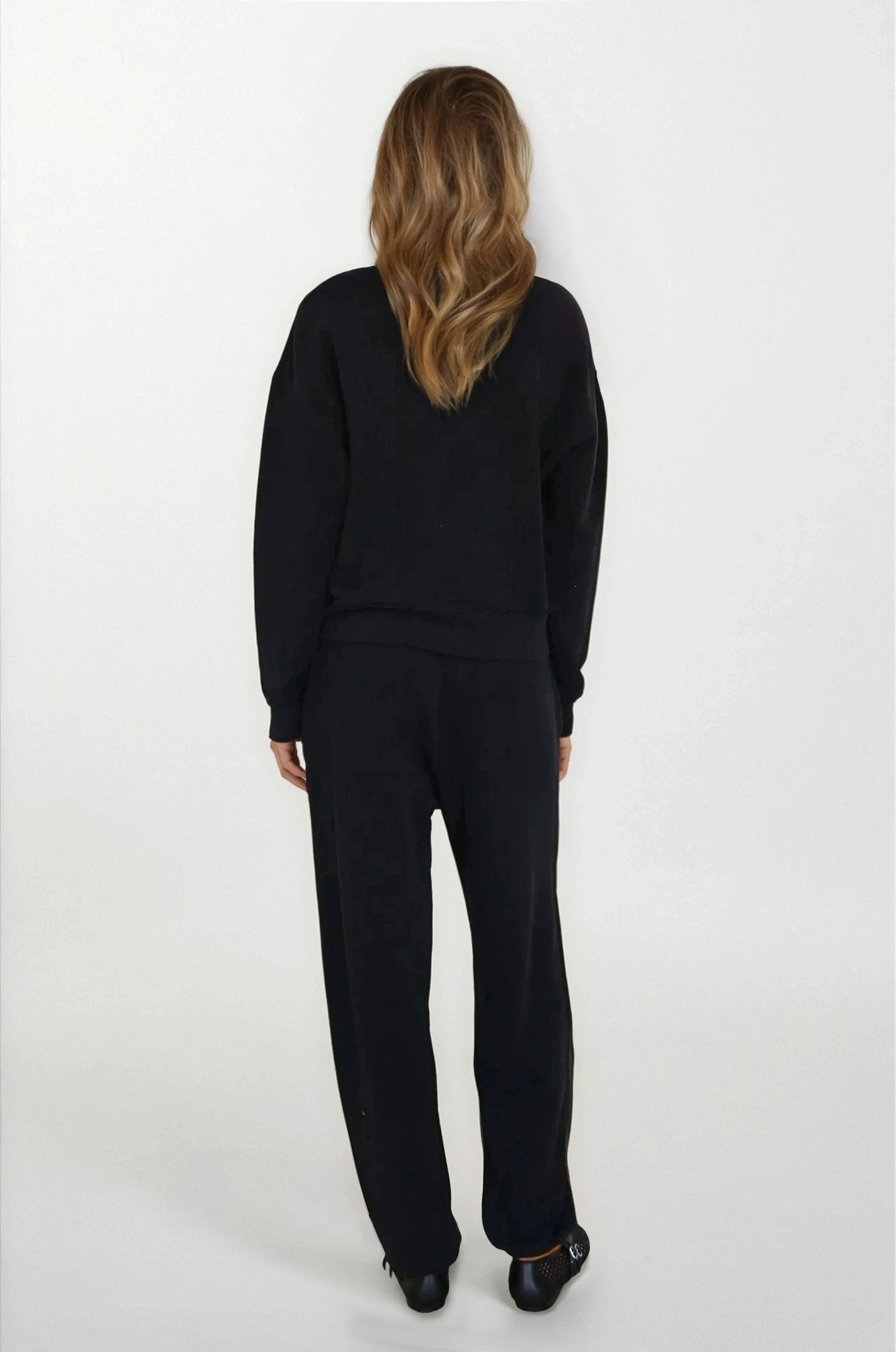 Person wearing a black outfit on a white background