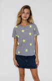 Woman wearing a gray t-shirt with yellow star patterns on a plain background