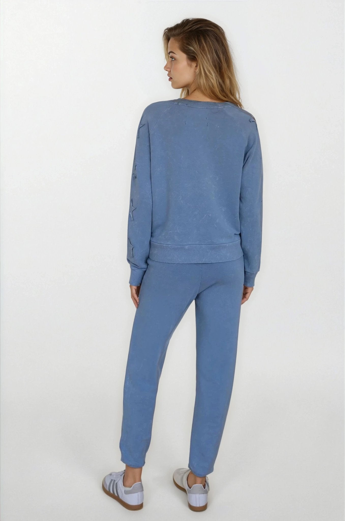 Woman wearing a blue tracksuit on a white background