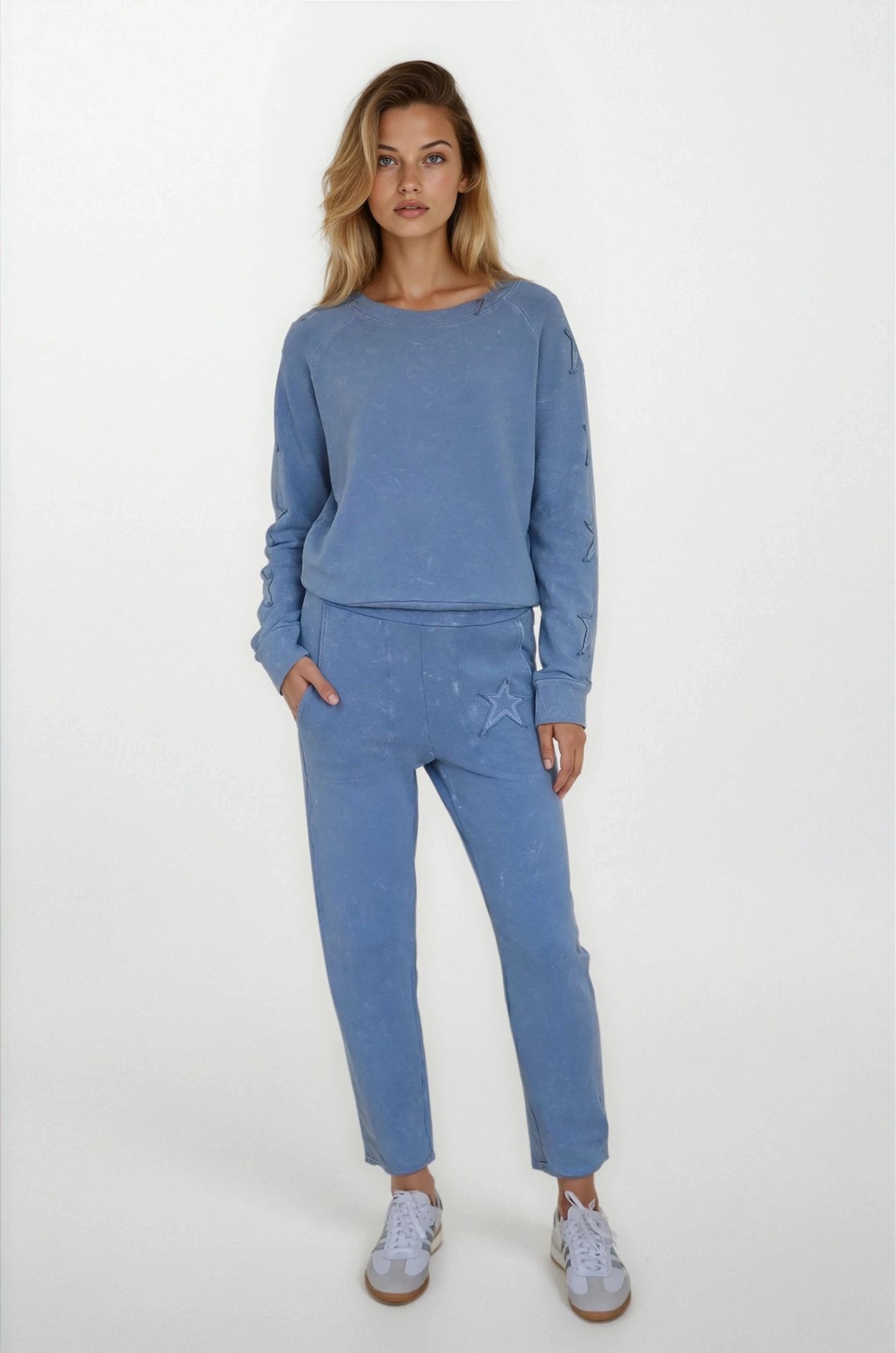 Woman wearing a blue outfit with a plain background