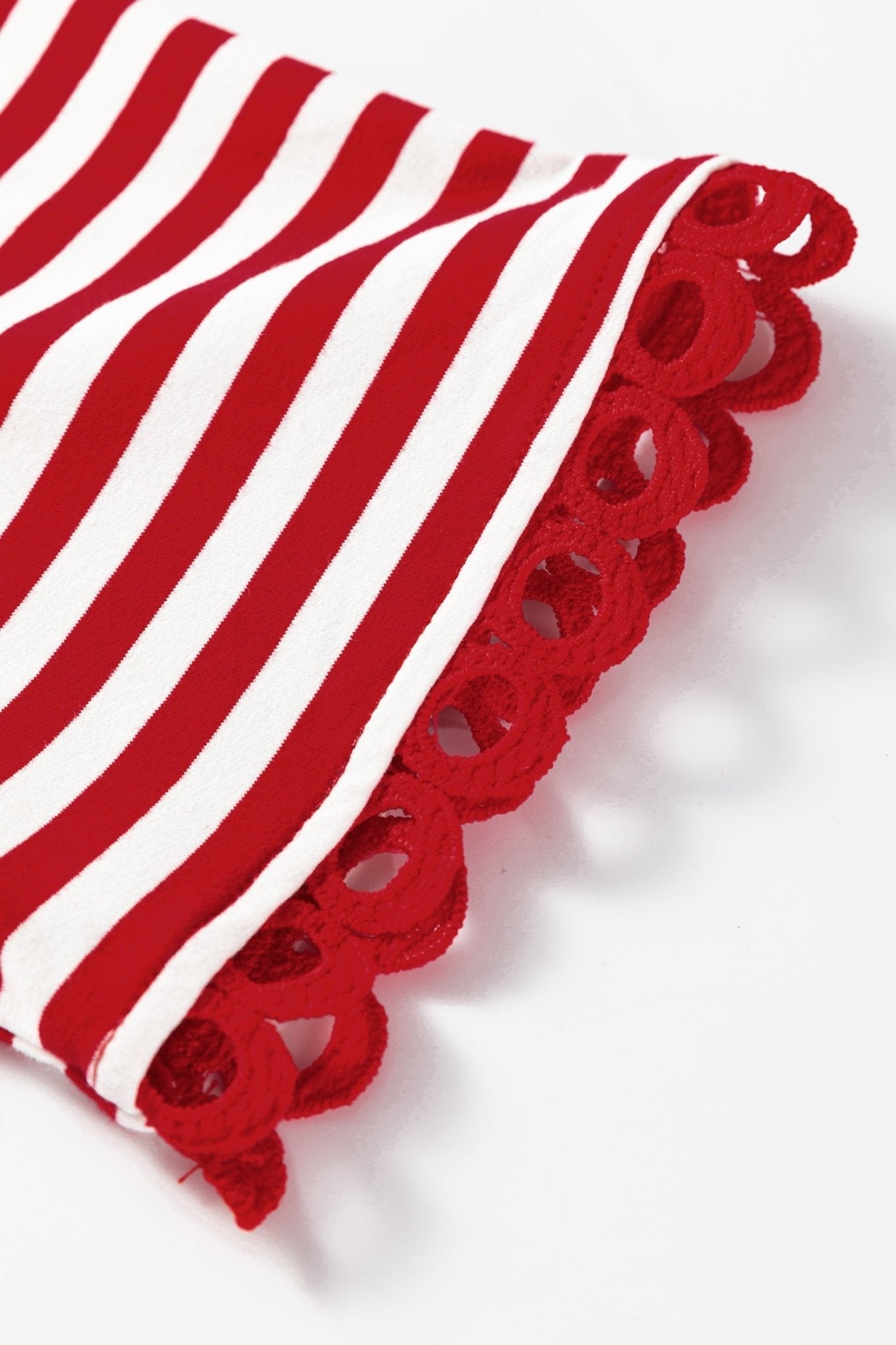 Red and white striped fabric with cut-out pattern on a white background