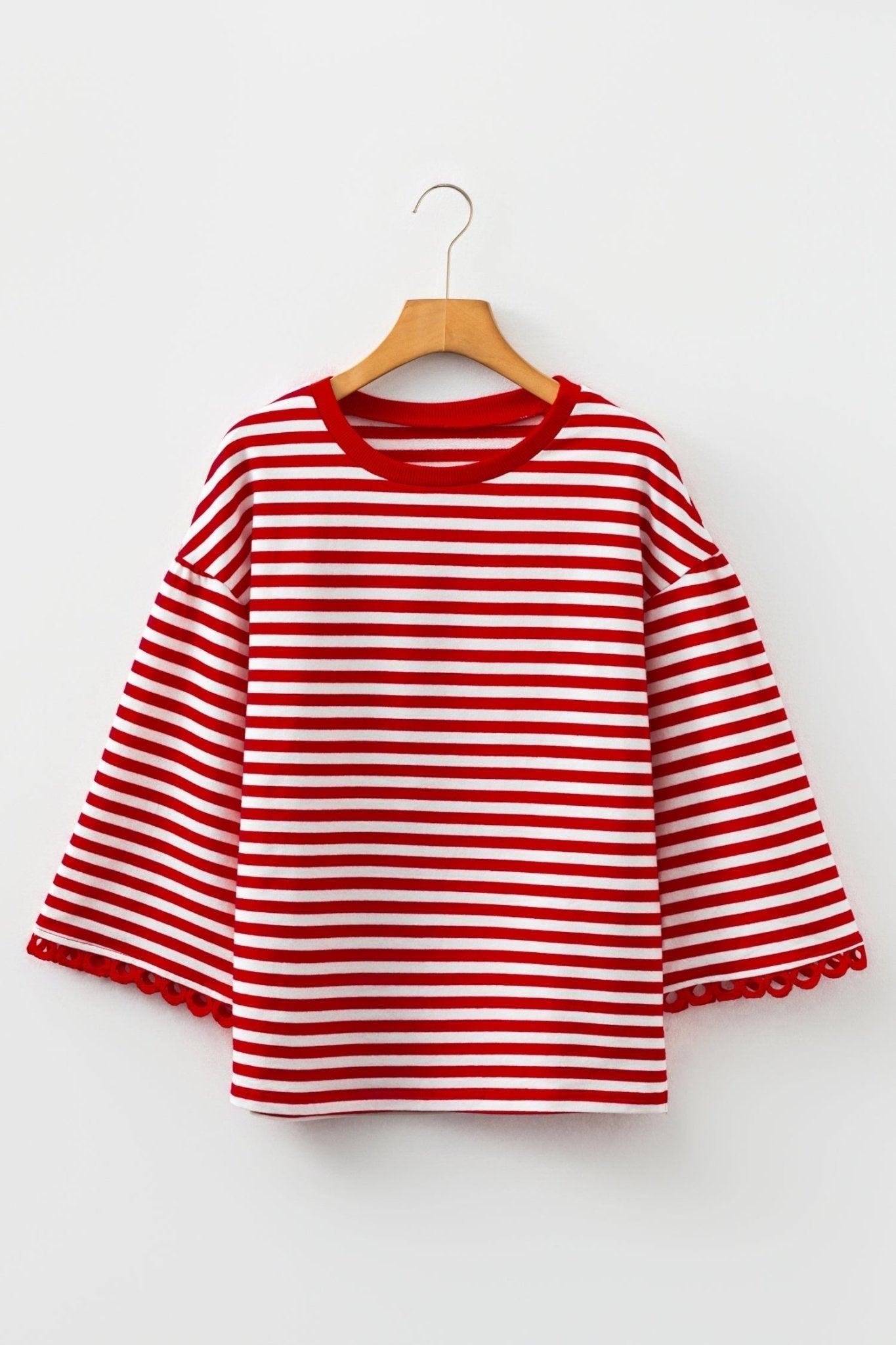 Red and white striped shirt on a hanger against a white background