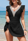 Woman wearing a black dress with lace details on a beach