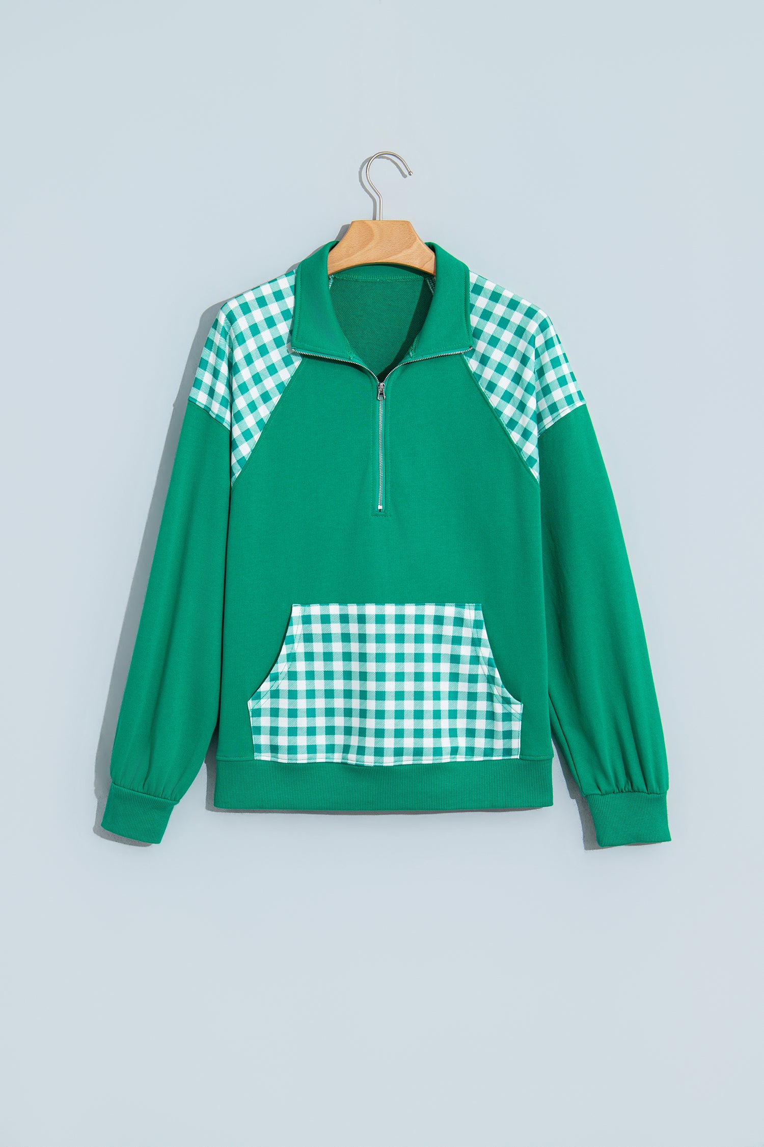 Dark green plaid quarter zip sweatshirt on hanger, front view