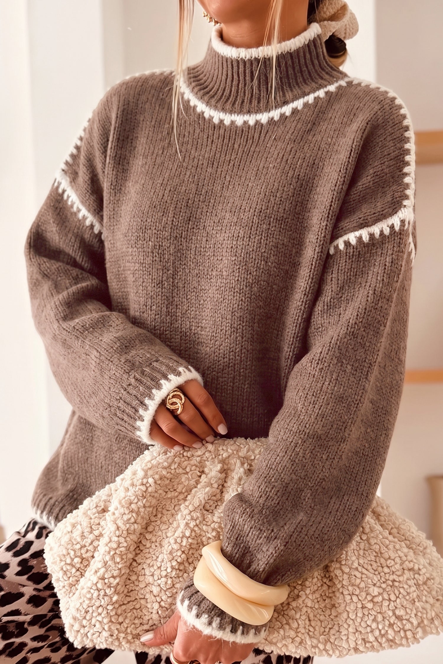 Dark khaki mock neck sweater with cream blanket stitch trim and a sherpa bag