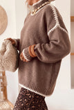 Side view of dark khaki drop shoulder sweater with cream contrast trim and leopard skirt