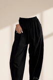 Black pants worn by a person on a beige background