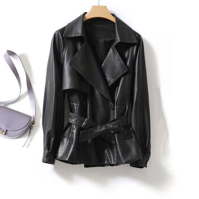 Black leather jacket on a hanger with a purple bag in the background