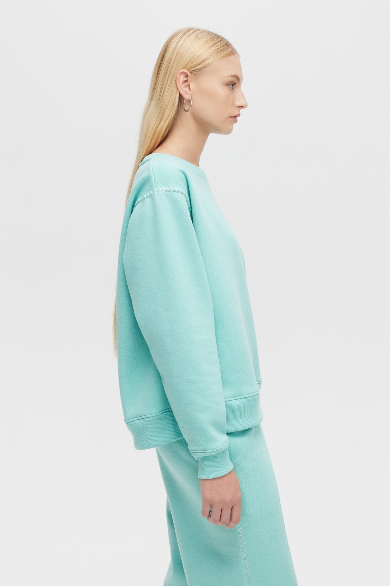Person wearing a light blue outfit on a white background