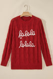 Red cable-knit “folala folala” sweater with white script on wooden hanger.