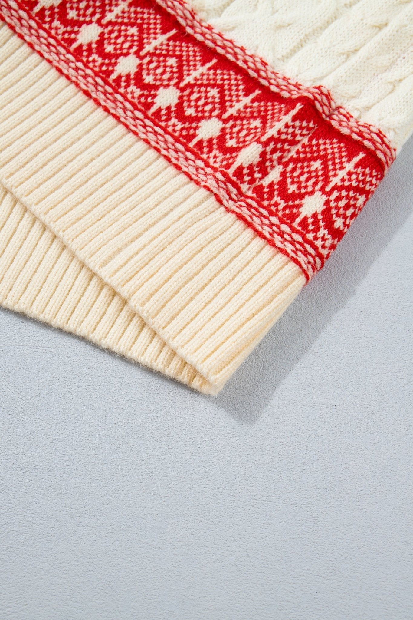 Close-up of cream ribbed knit sleeve with red Fair Isle patterned band