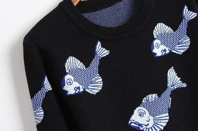 Black sweater with white fish patterns on a plain background