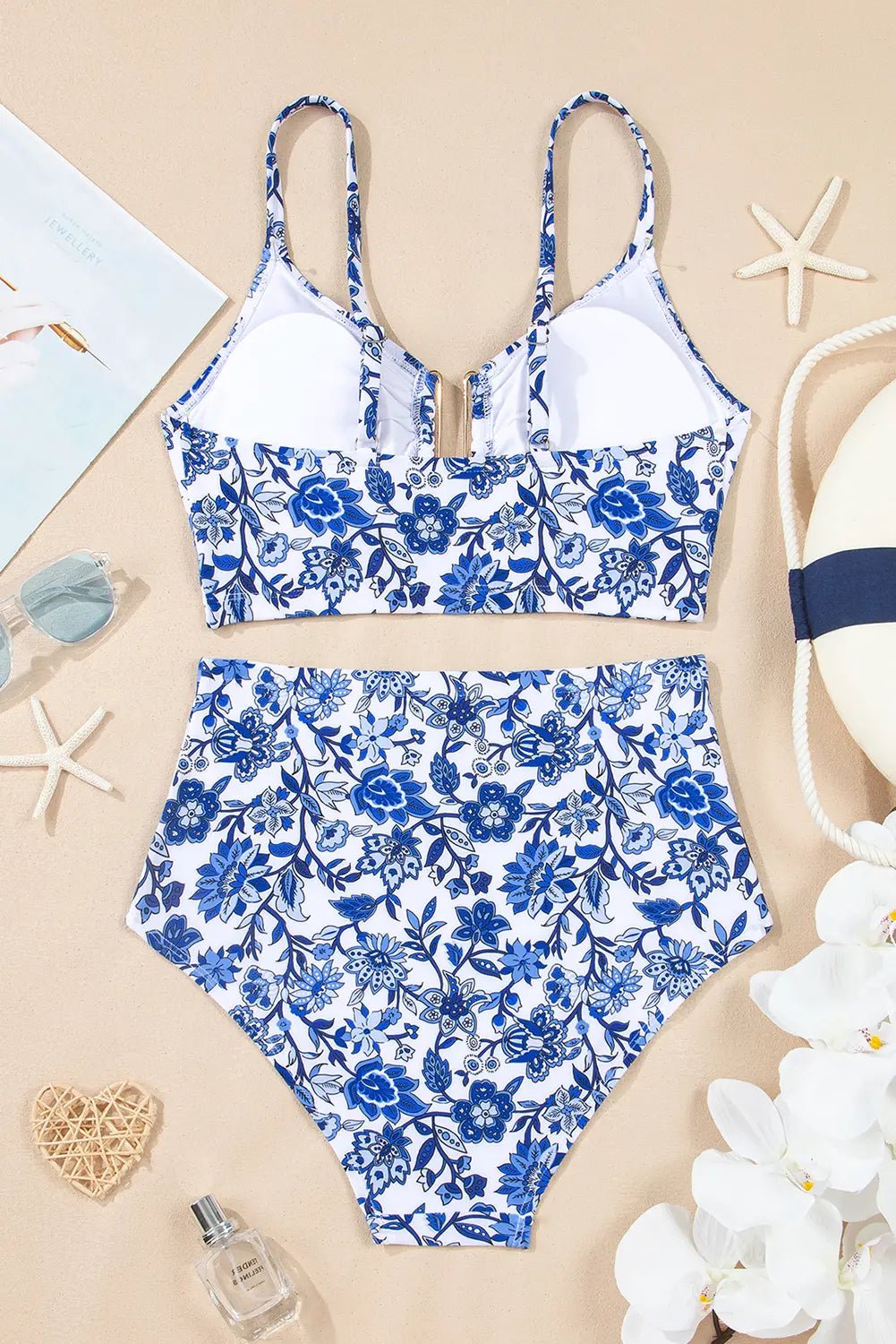 Blue floral swimsuit on a beige background with starfish and flowers.
