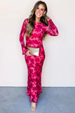 Woman wearing a pink floral dress holding a clutch against a white background