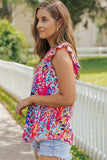 Woman wearing a colorful floral sleeveless top outdoors