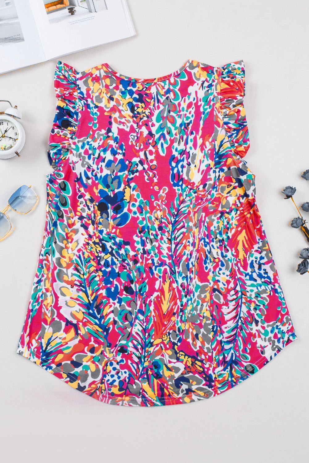 Colorful floral-patterned dress on a white surface with small decorative items around.
