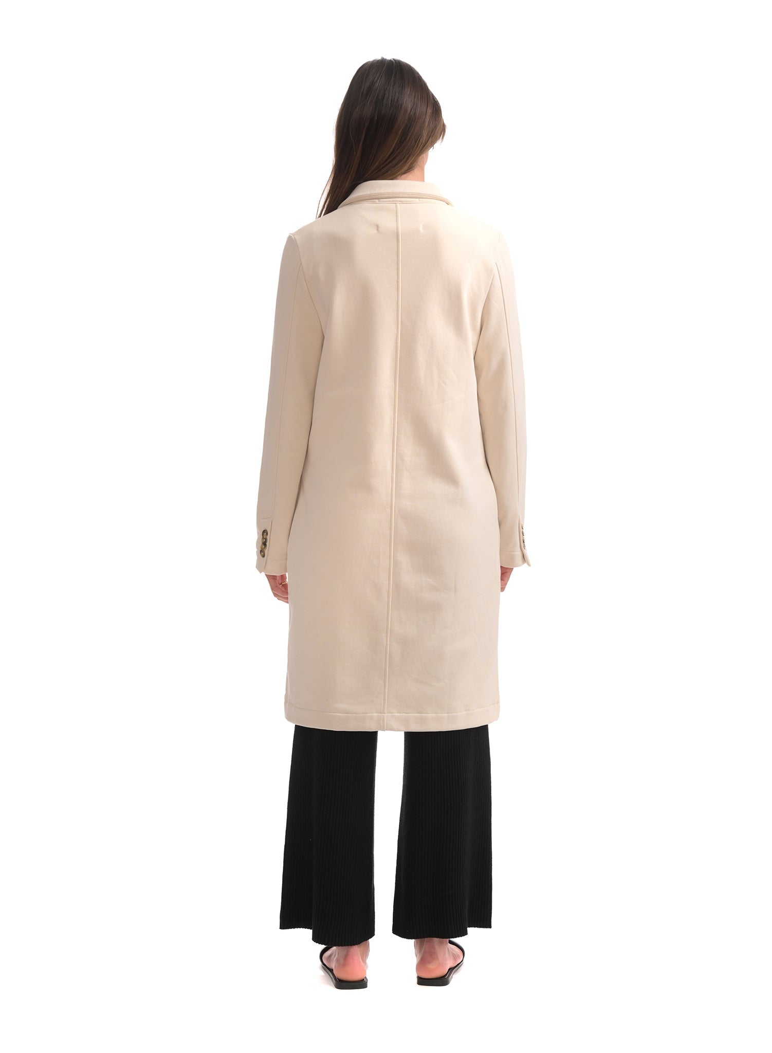 Woman wearing a beige coat on a white background