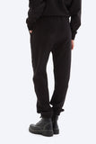 Person wearing black sweatpants and black shoes on a white background