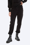 Person wearing black jogger pants and black boots on a white background