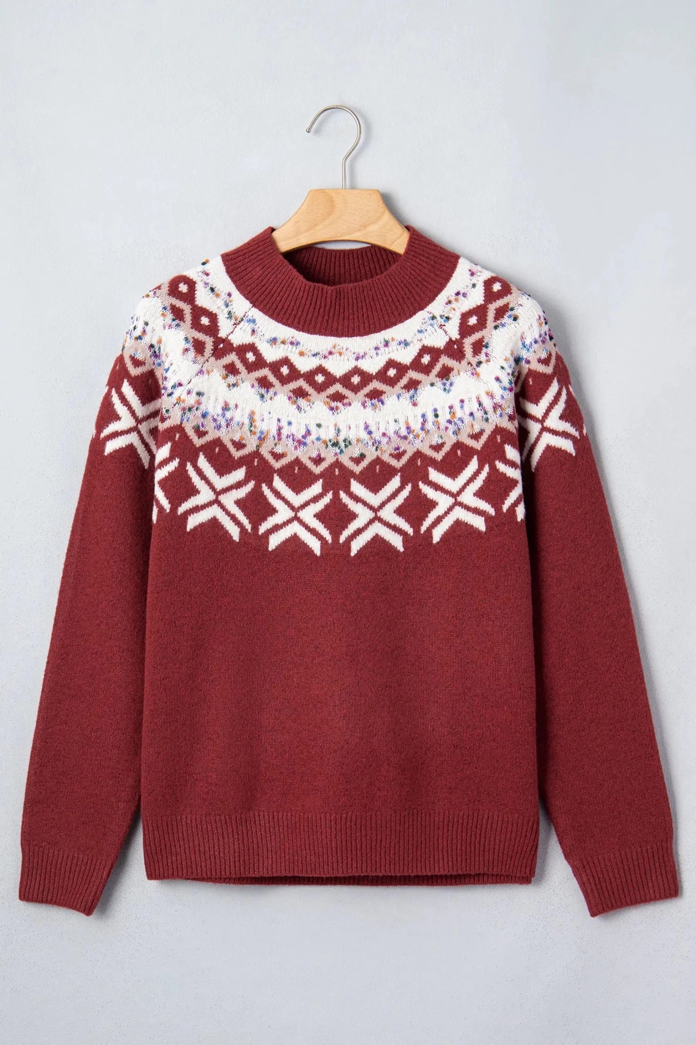 Burgundy crewneck sweater with a white and multicolor Fair Isle yoke on a hanger.