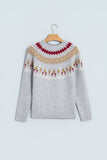 Light gray Fair Isle knit sweater with red, beige, and white pattern on hanger.