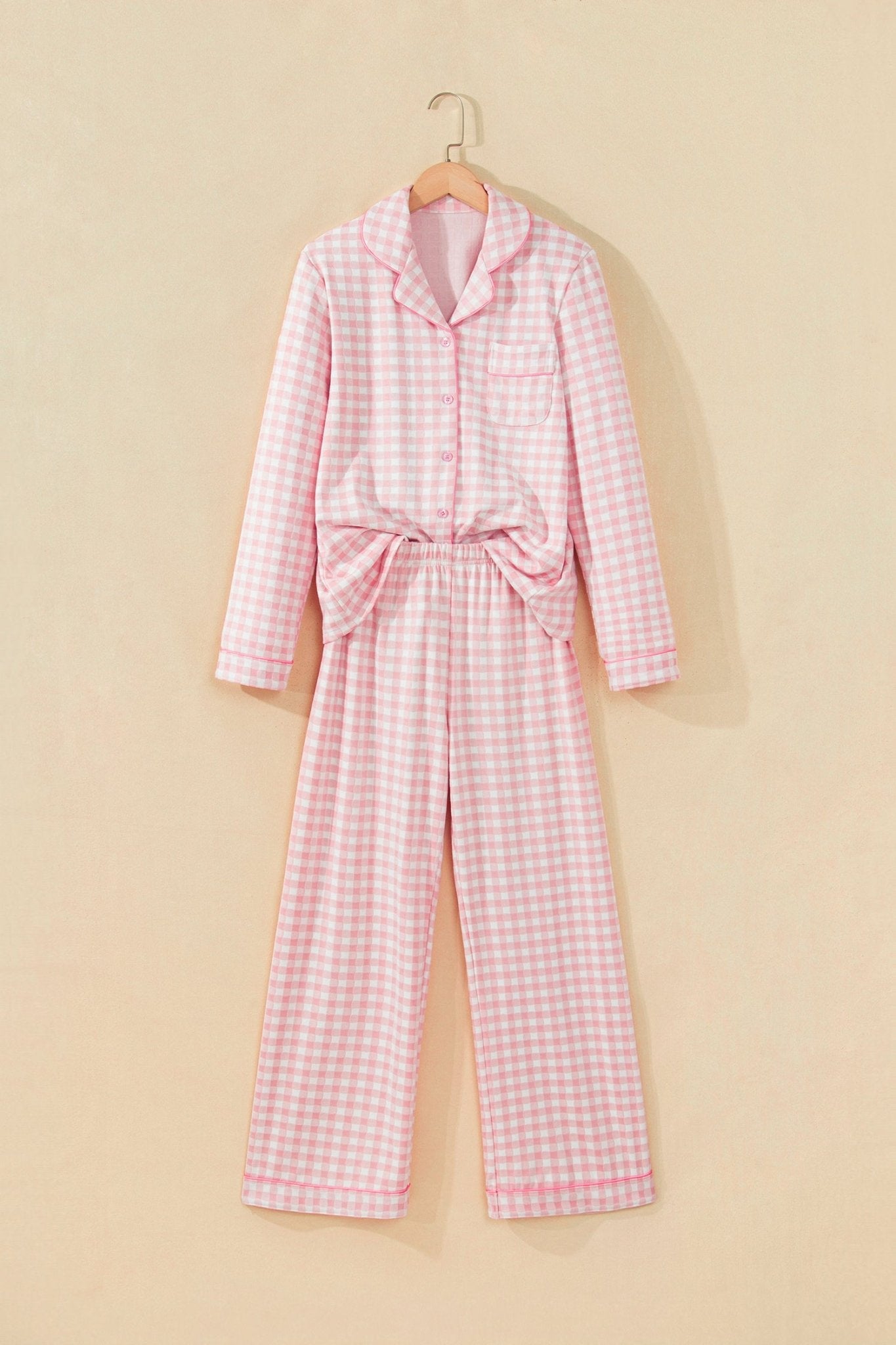 Pink-white gingham pajamas with collar, tie belt, and wide-leg pants on hanger.