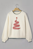 An off-white knit crewneck sweater hanging on a wooden hanger against a solid gray background. The sweater features a red and white gingham Christmas tree motif with a red star on the chest, and dark green contrast knit trim along the collar, hem, and cuffs.