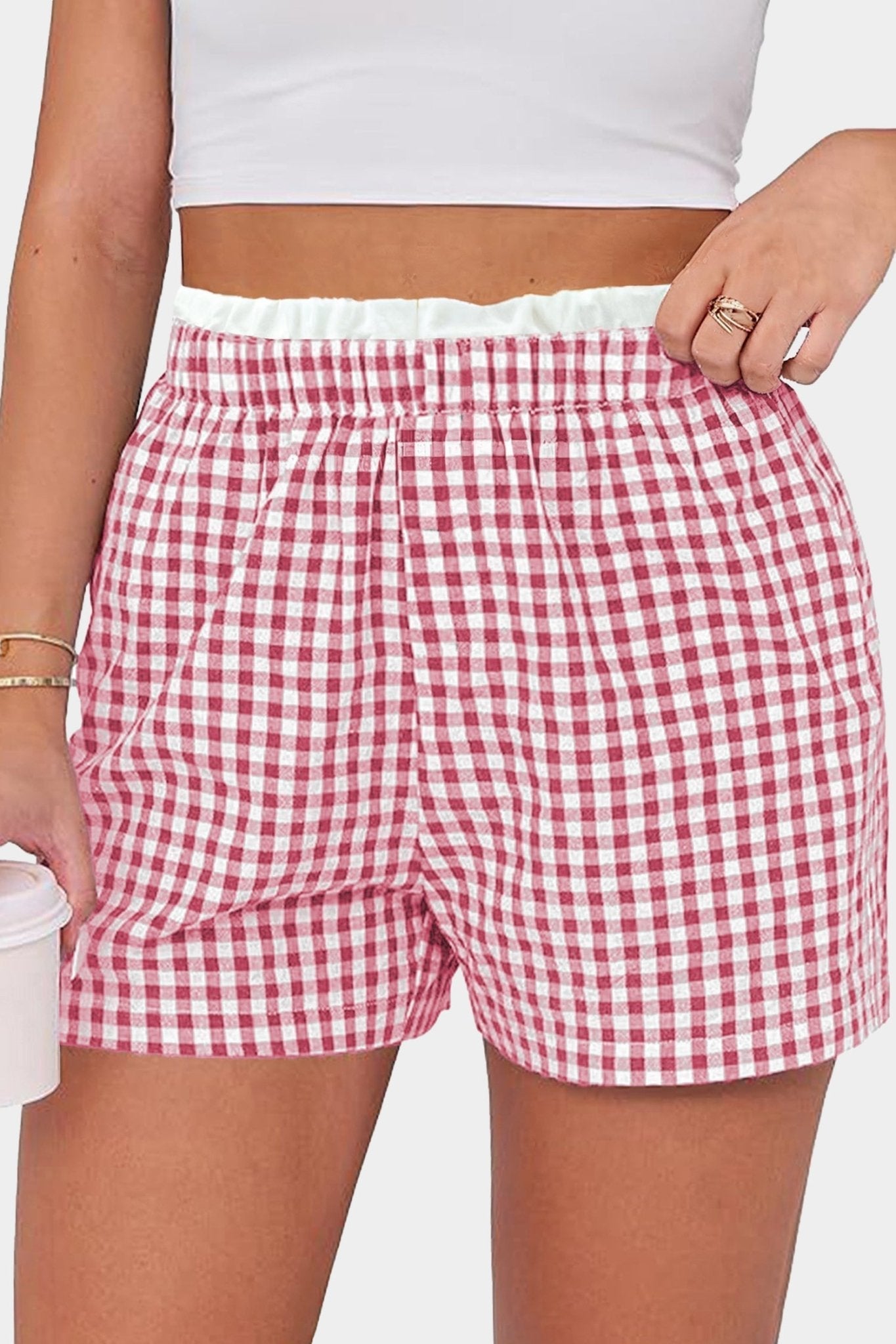 Red and white checkered shorts worn by a person on a plain background