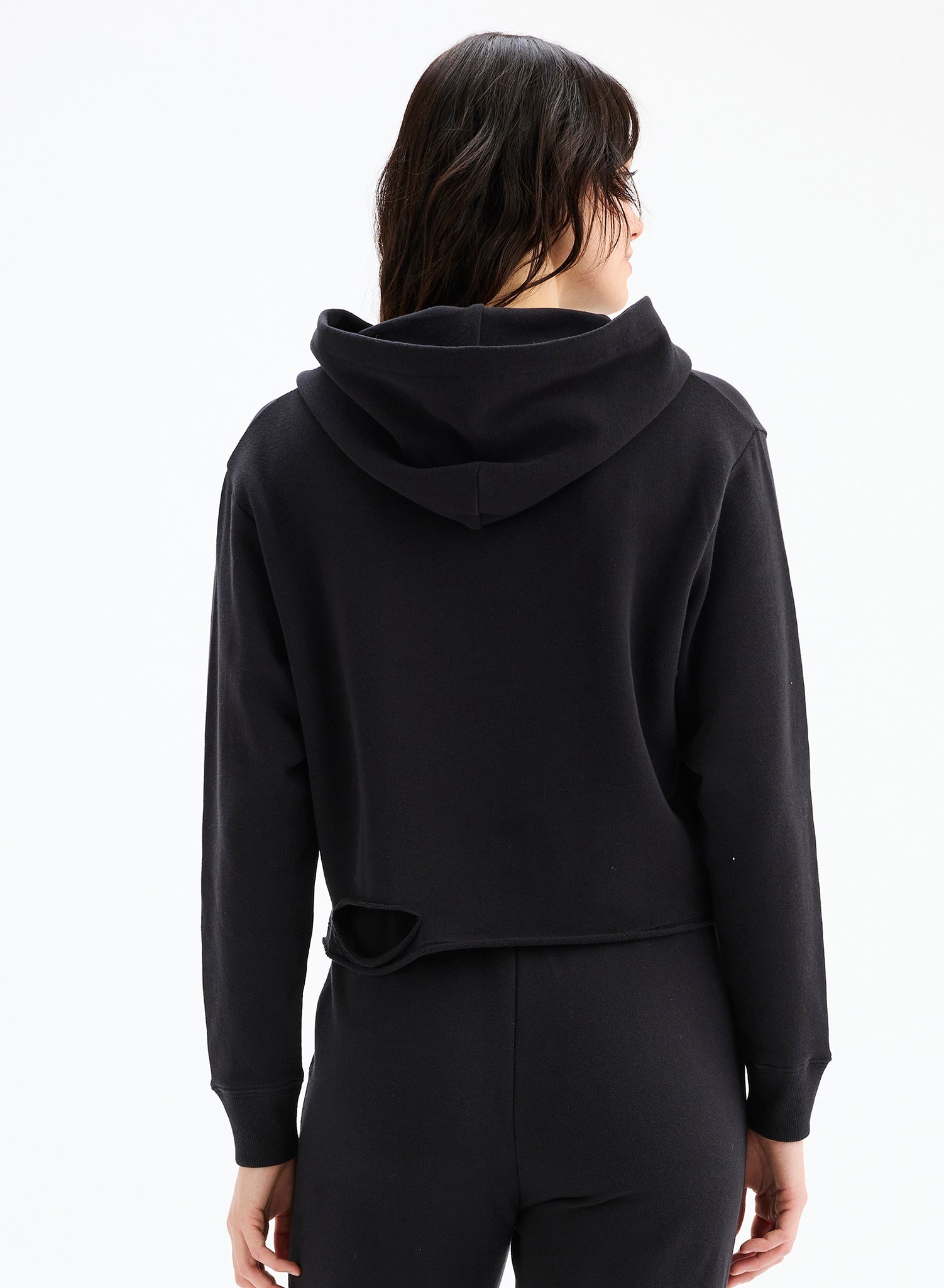 Person wearing a black hoodie from behind on a white background