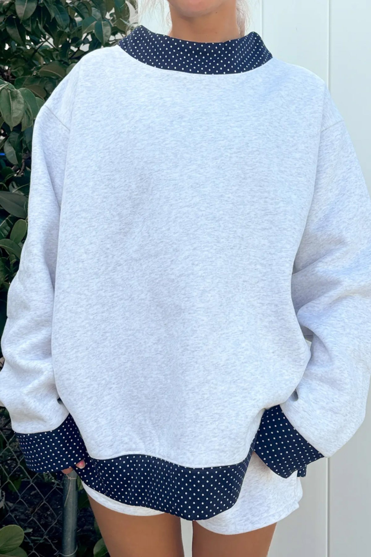 Women's gray sweatshirt with navy polka dot trim at neck, cuffs and hem, front view