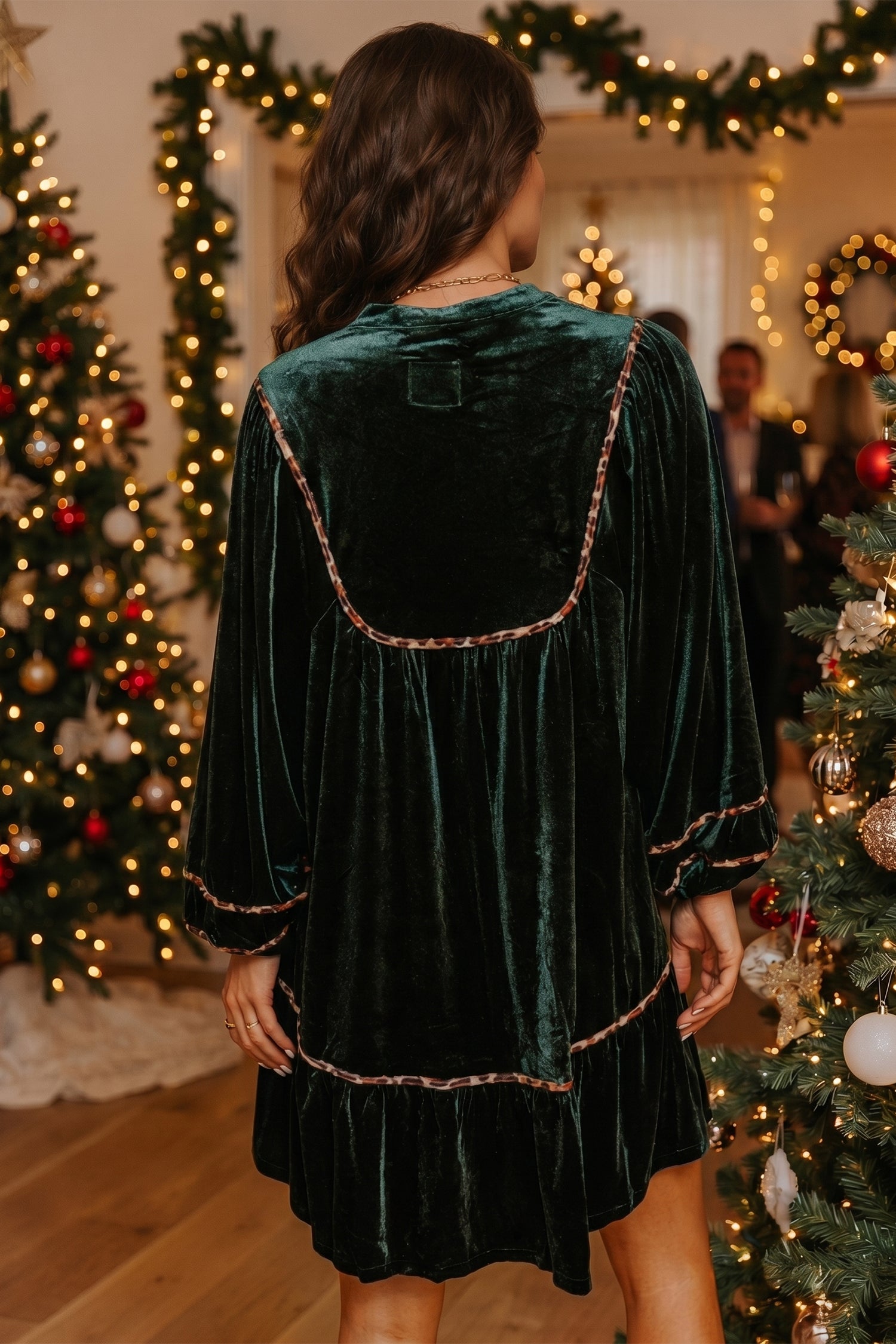 Back view of green velvet shift dress with leopard trimmed yoke and ruffle hem