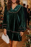 Woman in blackish green velvet leopard trim shift dress holding a white clutch