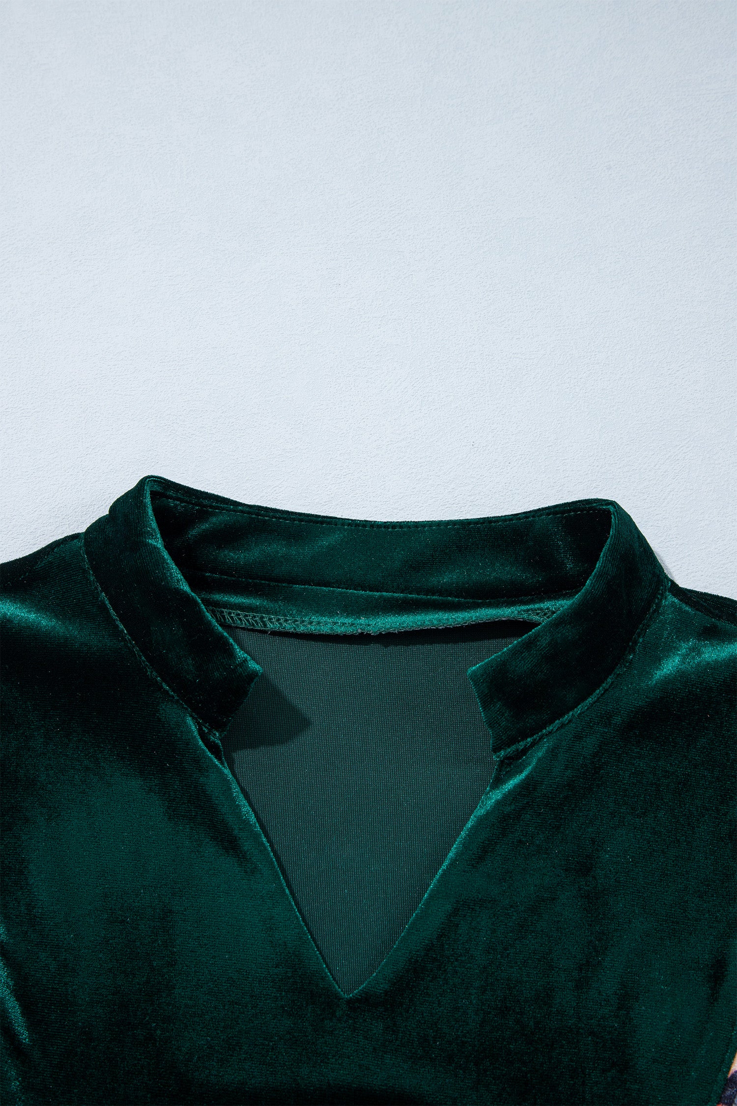 Split V neckline with small stand collar on green velvet dress