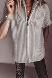 Person wearing a light gray chunky knit zip cardigan with high collar and leather pants.