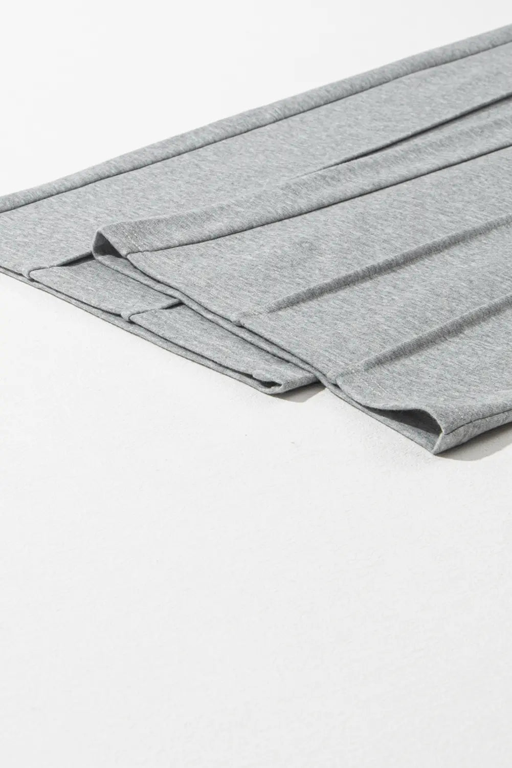 Close-up of folded gray knit fabric with soft texture and ribbed edge.