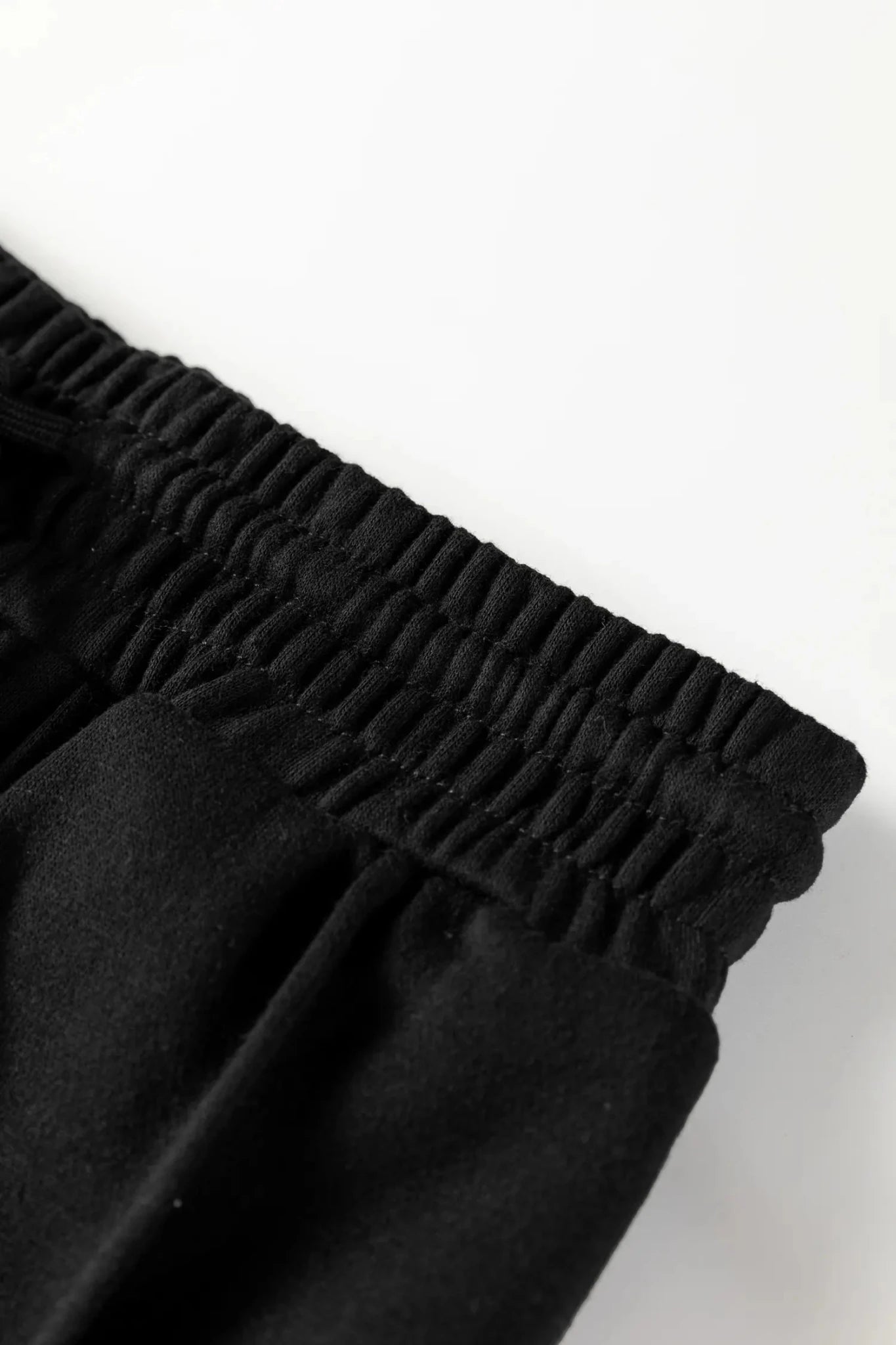 Black pants with an elastic waistband on a white background