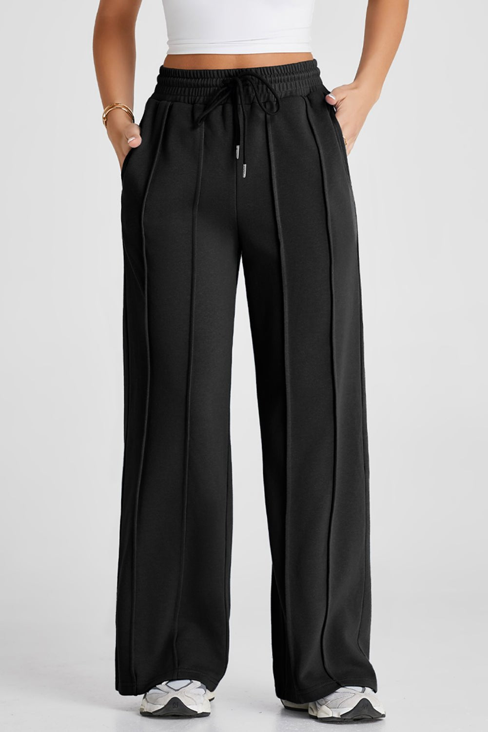 Black wide-leg sweatpants with drawstring waist, side pockets, and pleats.