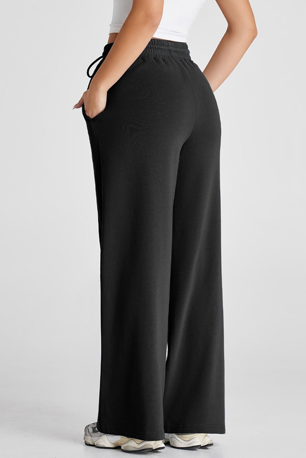 Black wide-leg pants worn by a person on a white background